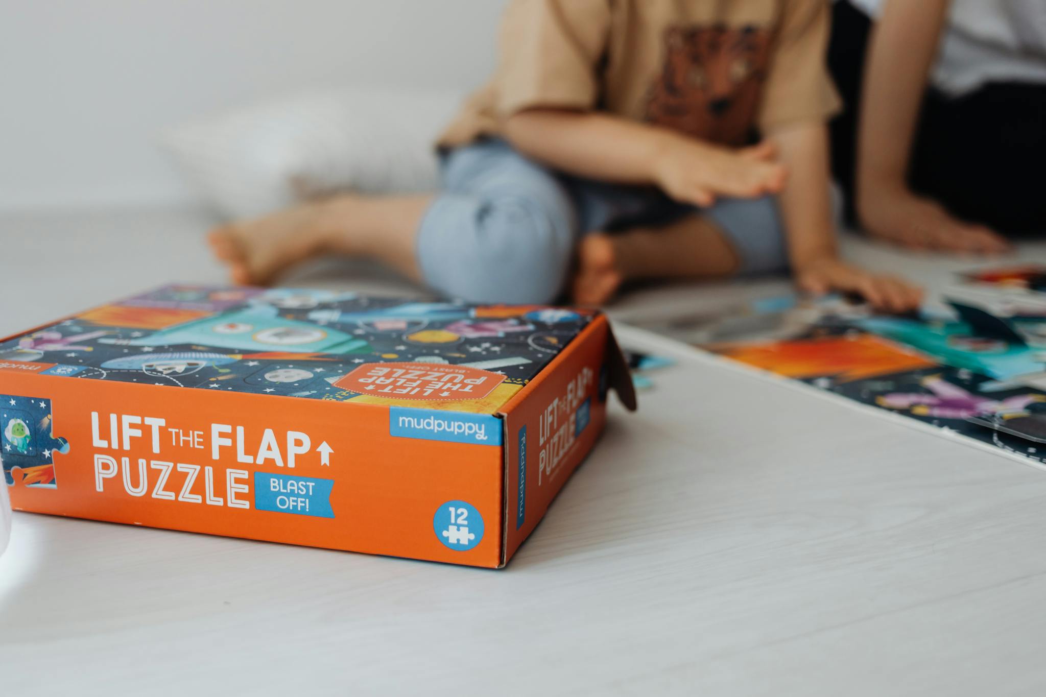Close-up of children playing a fun and educational lift the flap puzzle game indoors.